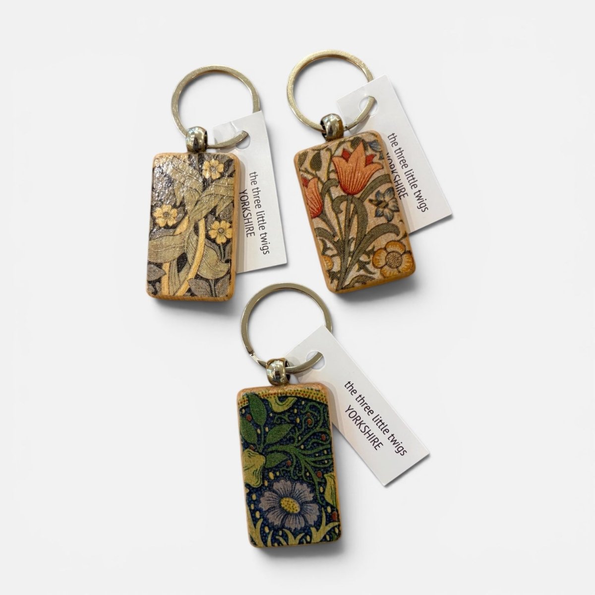 Three rectangular keychains with floral artwork from William Morris&
