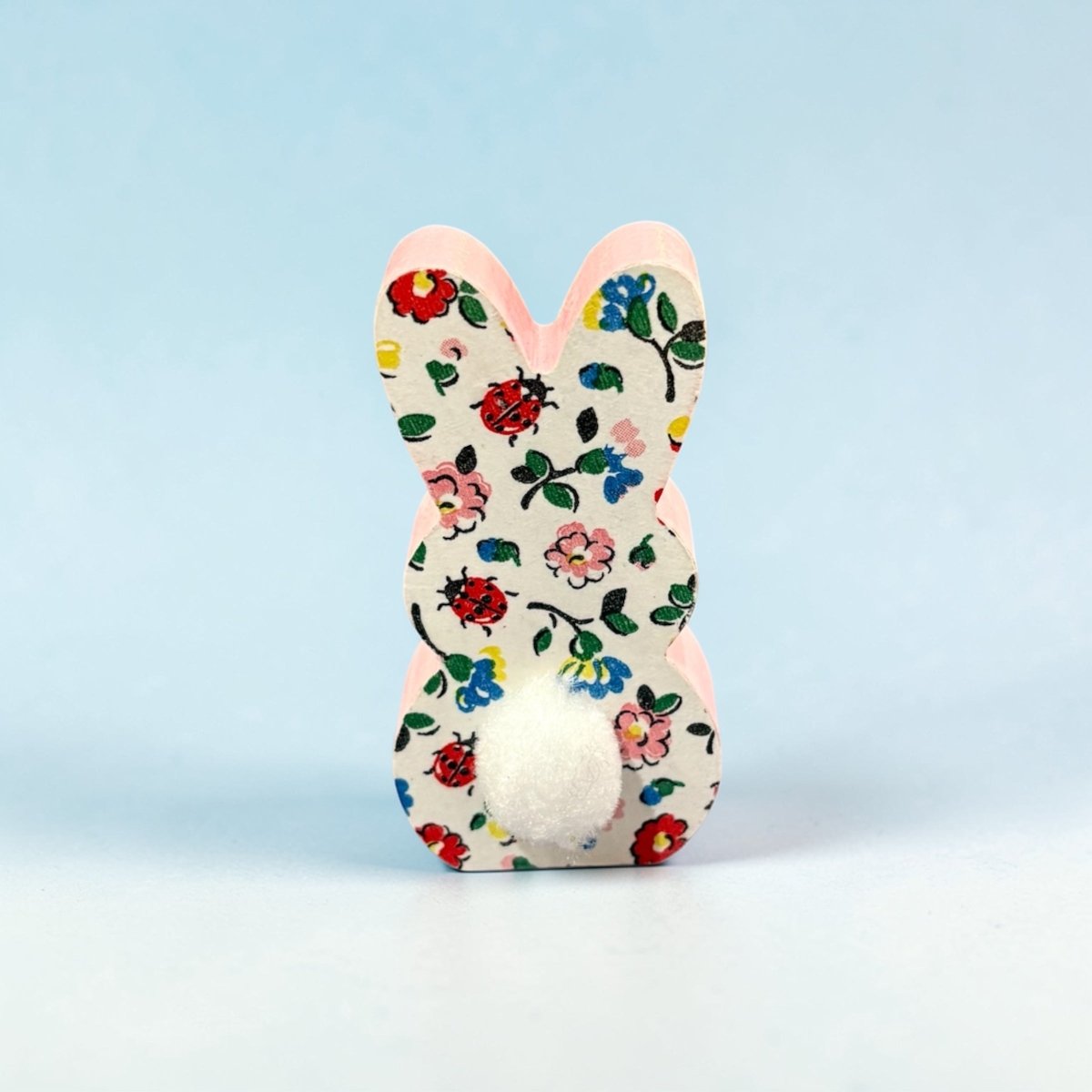 Decorative bunny with floral and ladybug pattern on a light blue background