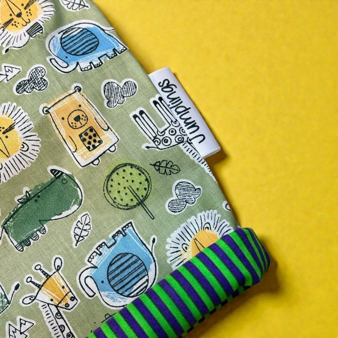 Fabric with animal pattern and striped edge on a yellow background