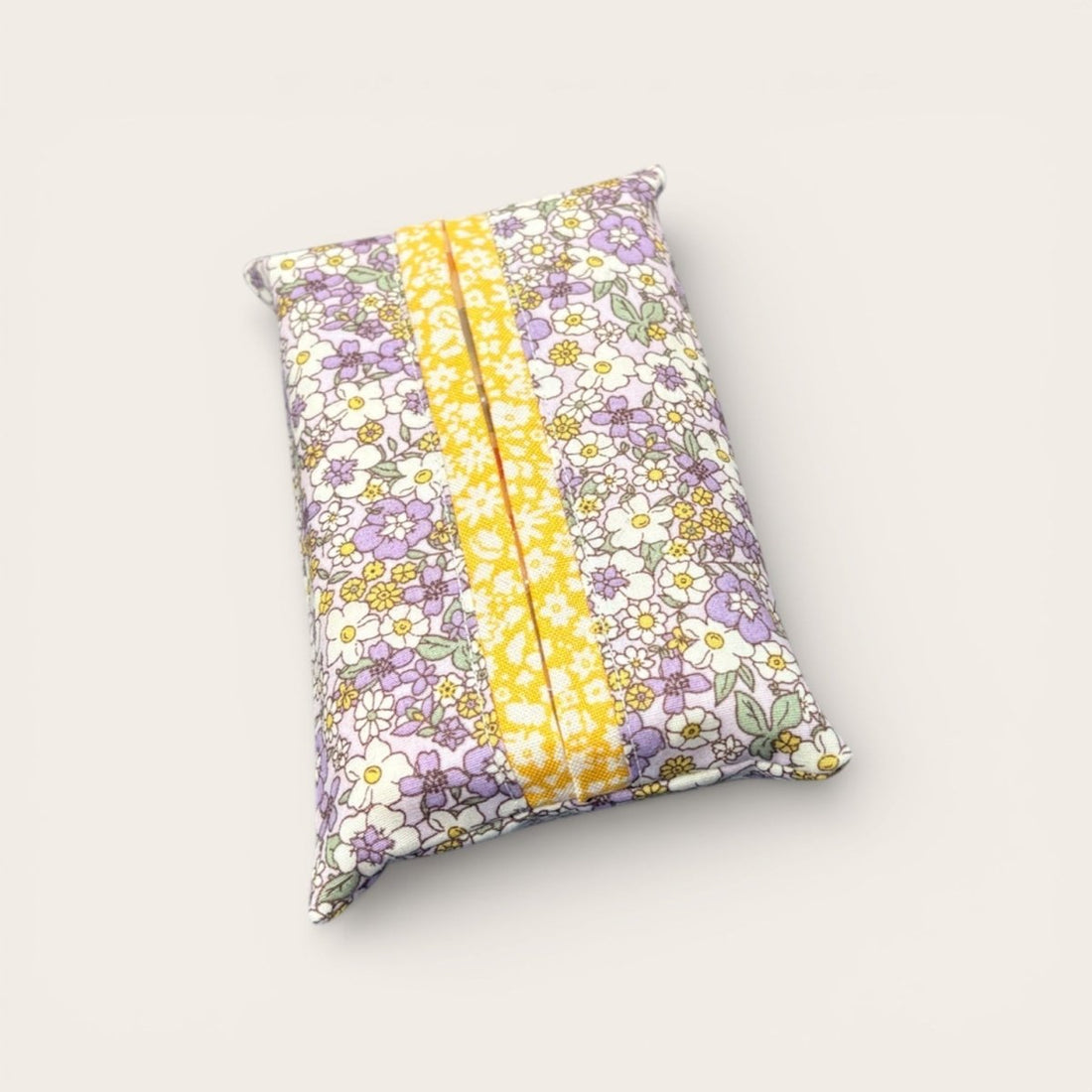 Floral-patterned pillow with a yellow stripe on a light gray background