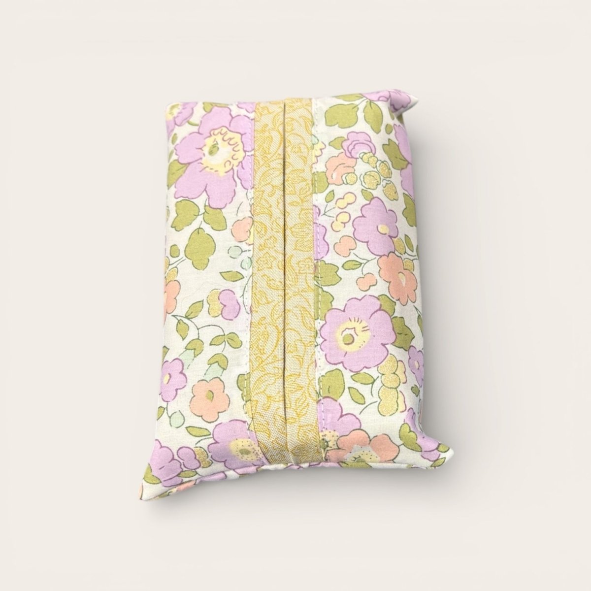 Floral-patterned tissue holder with a yellow stripe on a light gray background