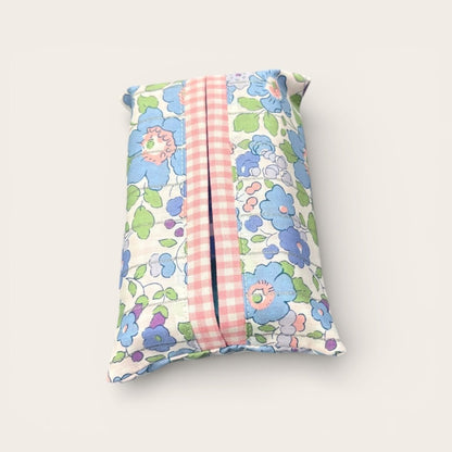 Floral-patterned tissue holder with a pink striped center on a white background