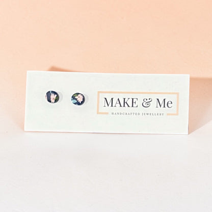 Make &amp; Me earrings on a branded card with a pink background
