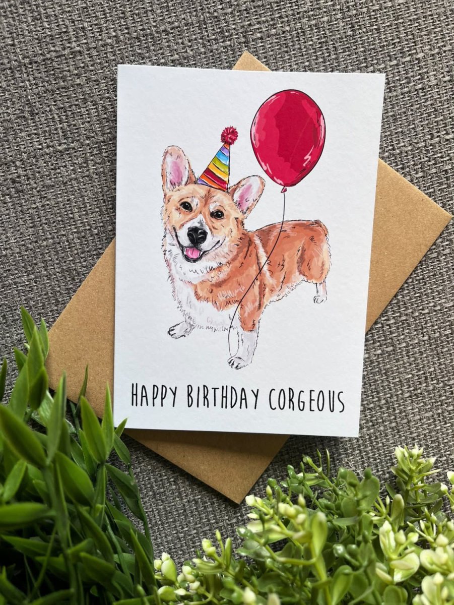 A greeting card featuring a watercolor-style corgi wearing a party hat and holding a red balloon, with the text &