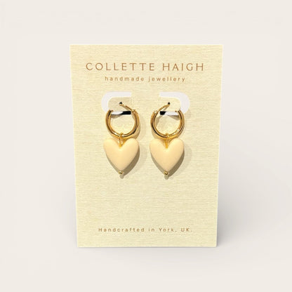 Heart-shaped earrings on a Collette Haigh branded card with a beige background