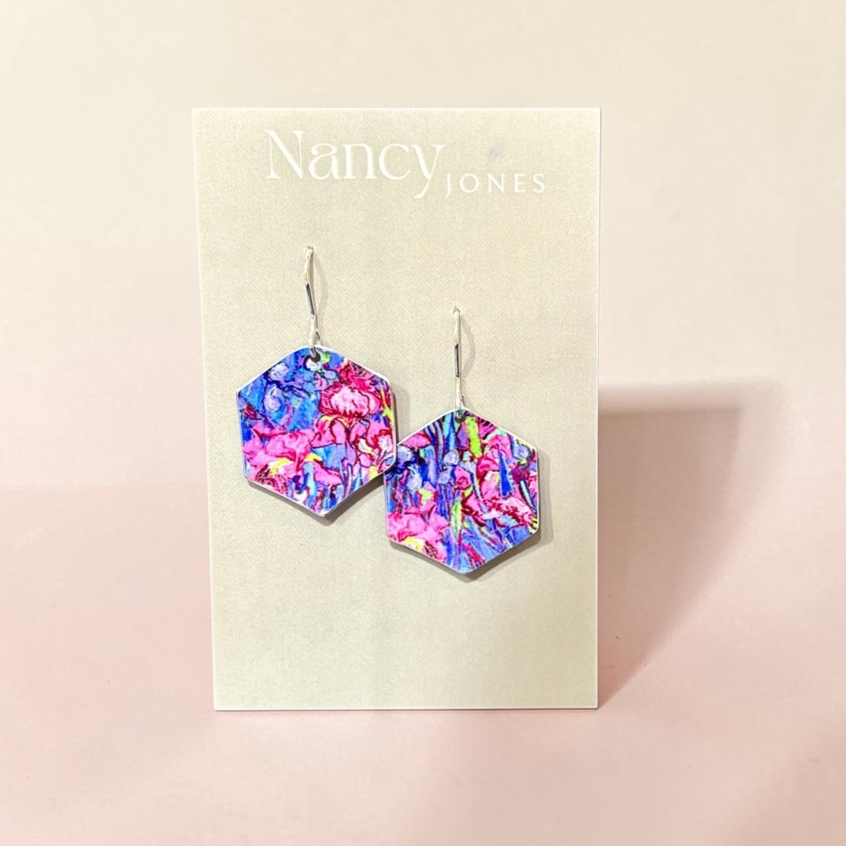 Hexagonal multicolored earrings on a Nancy Jones card against a beige background