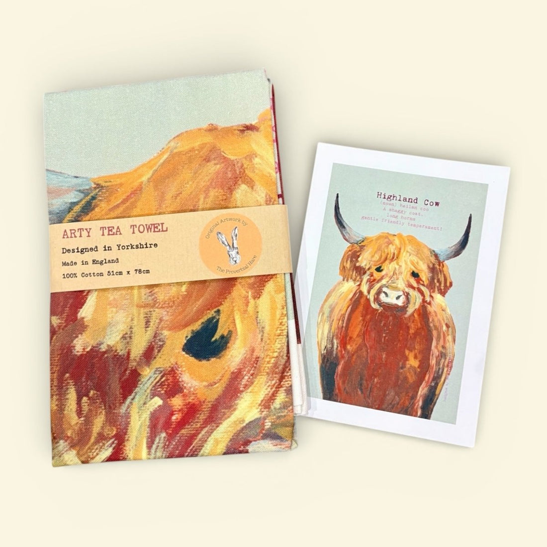 Tea towel with highland cow design and matching card on a light background