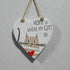 Heart-shaped sign with a cat illustration and text &