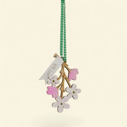 Decorative hanging ornament with flowers and a tag on a beige background