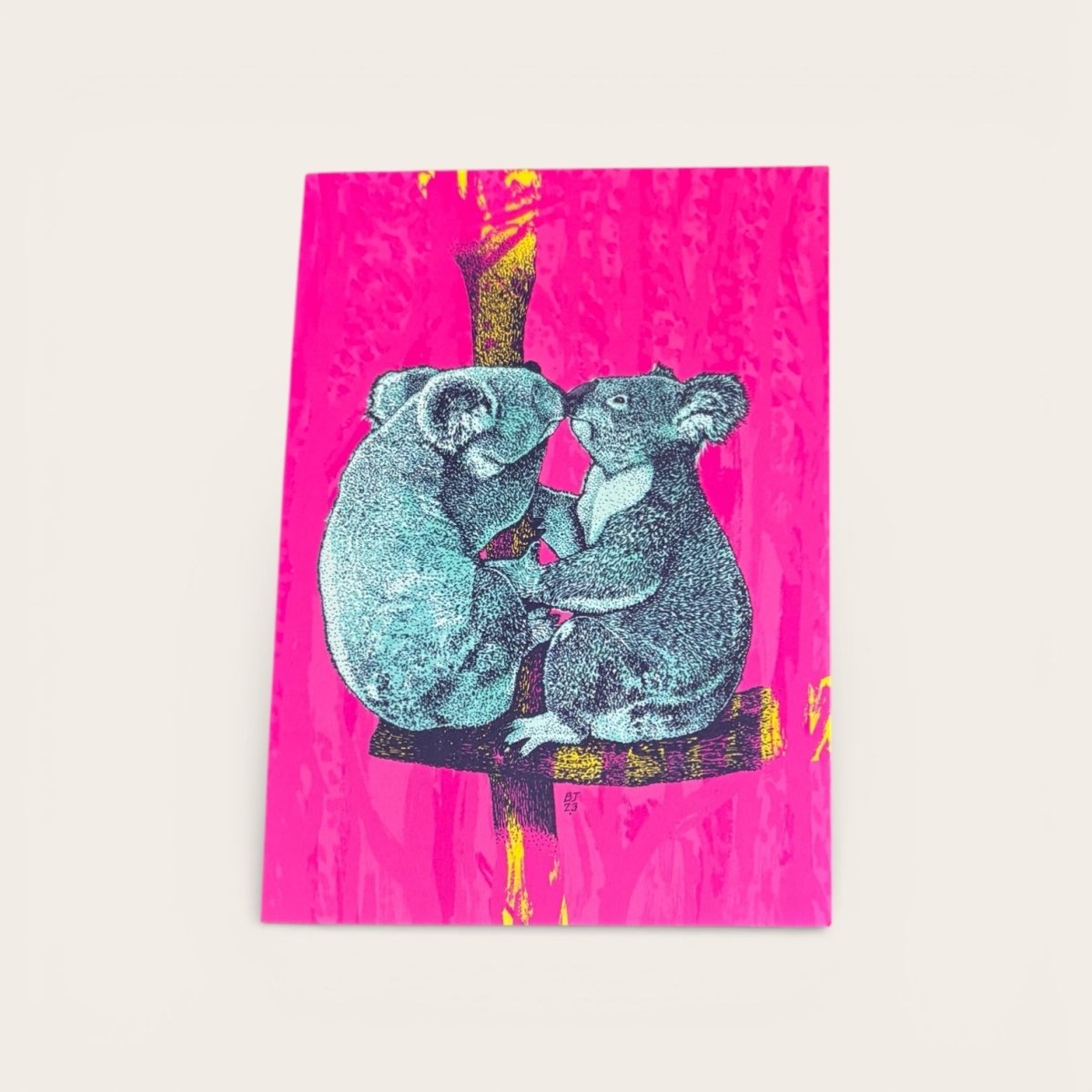 Two koalas on a branch with a pink background