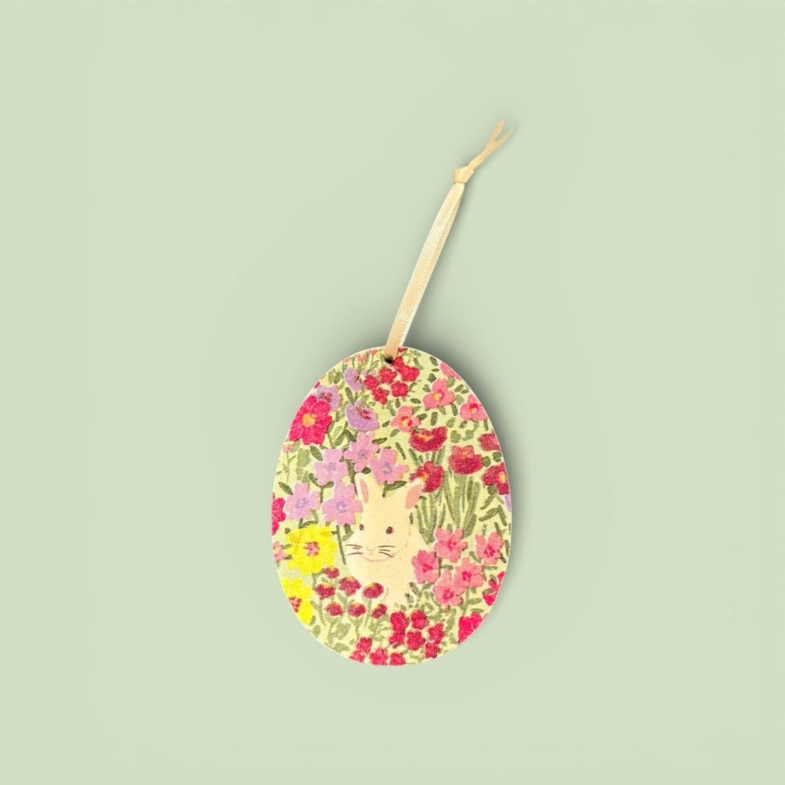 Decorative Easter egg with floral pattern and bunny design on a light green background