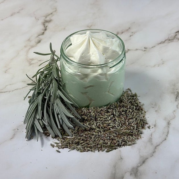 Glass jar with whipped cream on a marble surface with lavender leaves