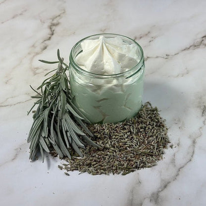 Glass jar with whipped cream on a marble surface with lavender leaves