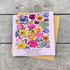 Greeting card with floral design and quote on a wooden surface