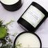 Two candles with labels on a white surface, one of which is open to reveal a green interior.