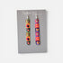 Colorful earrings on a Nancy Jones card against a white background