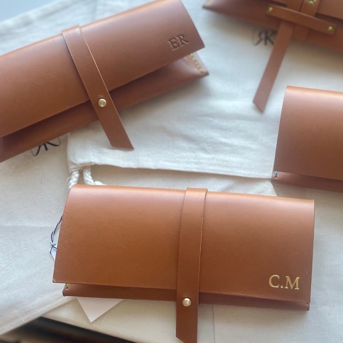 Brown leather cases with initials on a light background