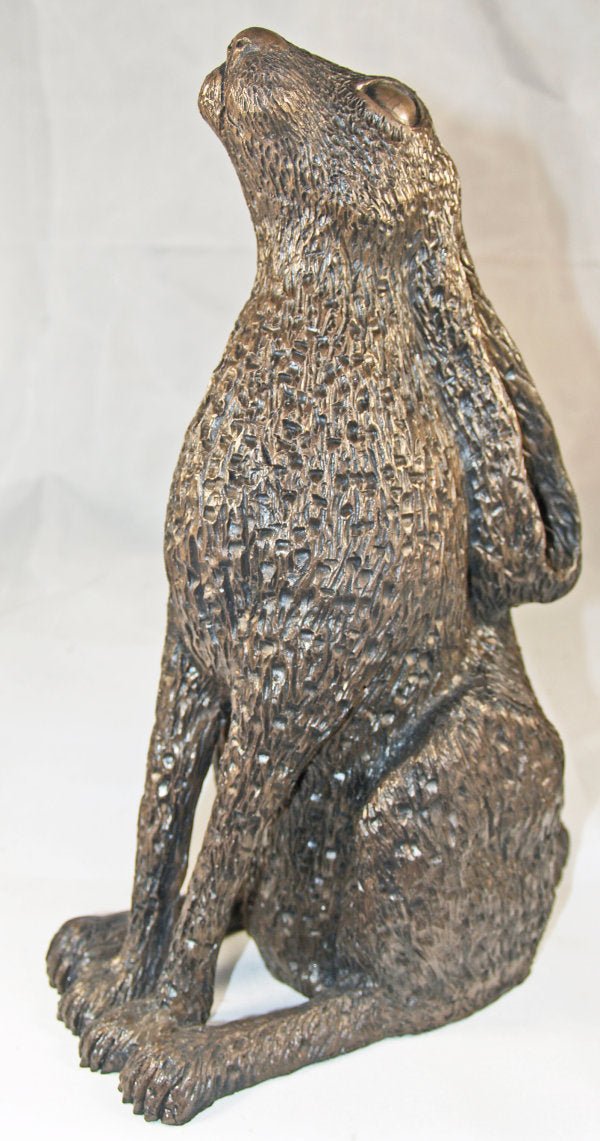 A textured bronze-finished sculpture of a sitting hare, shown against a plain white background.