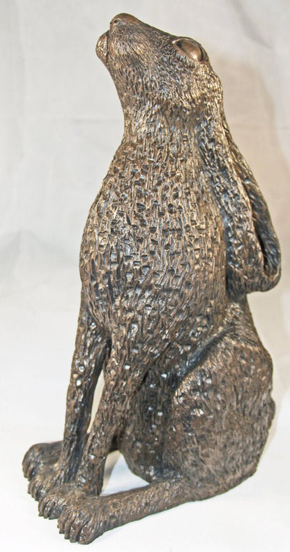 A textured bronze-finished sculpture of a sitting hare, shown against a plain white background.