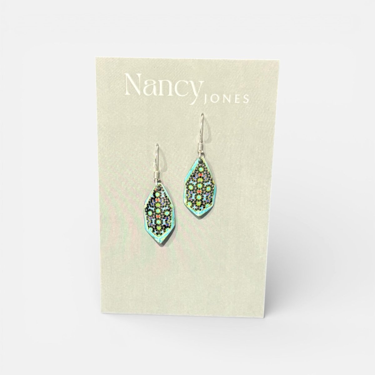 Teardrop-shaped earrings on a Nancy Jones card against a white background