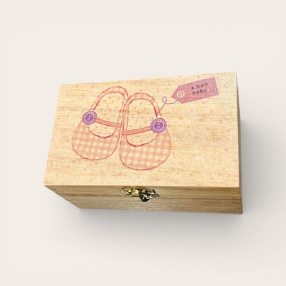 Wooden box with baby shoes illustration and &