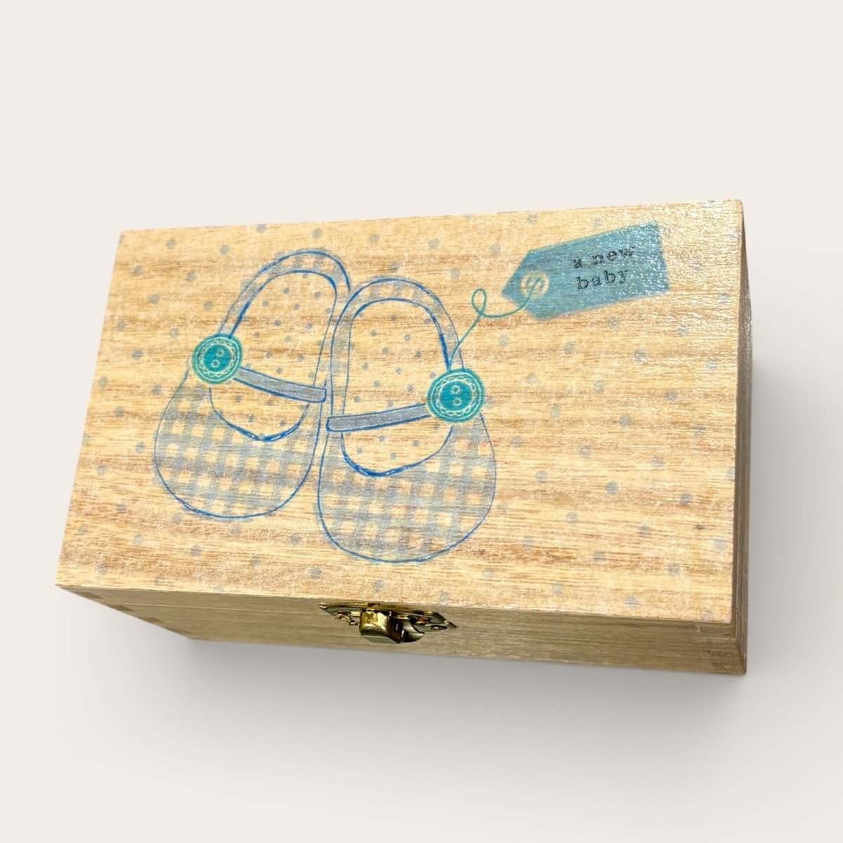 Wooden box with baby shoes illustration and &