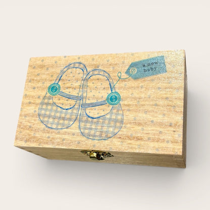 Wooden box with baby shoes illustration and &