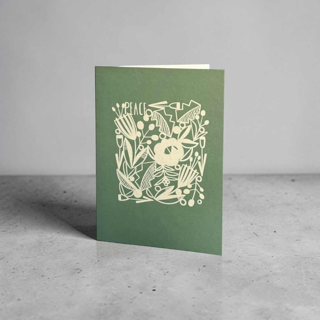 Green card with white floral design and &