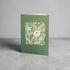 Green card with white floral design and &
