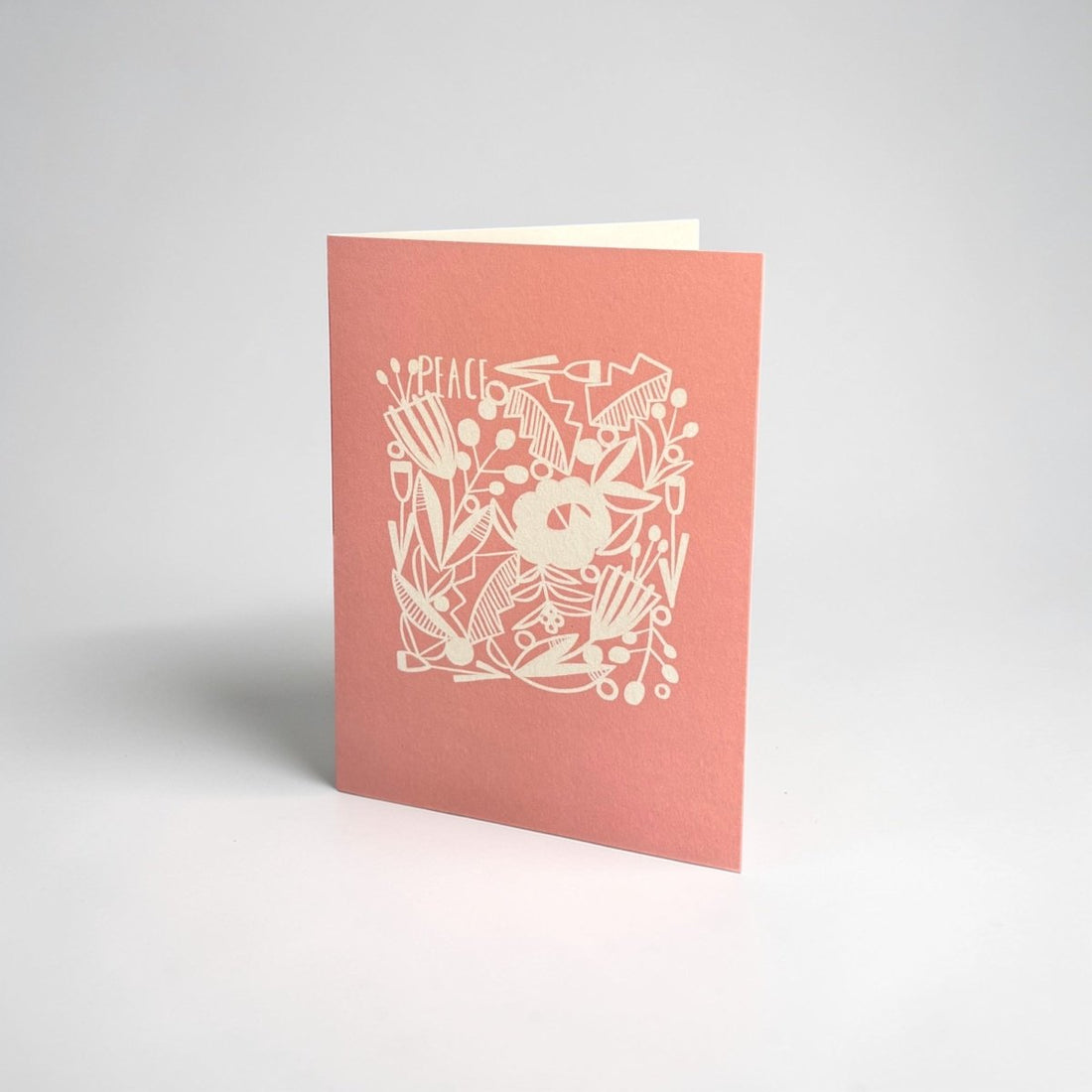 Pink greeting card with white floral design and &