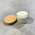 Candle with wooden lid on a concrete surface