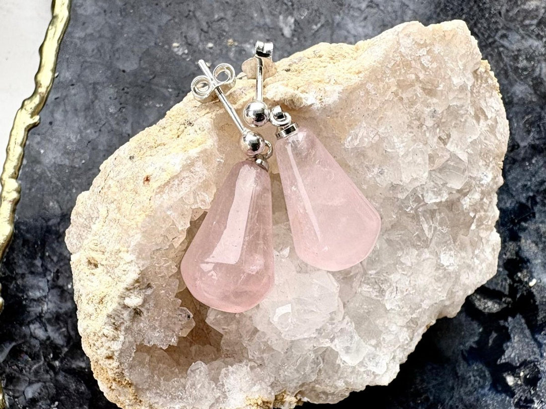 Pink teardrop earrings on a stone background
