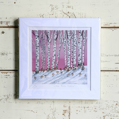 Framed artwork of a snowy landscape with birch trees on a pink background