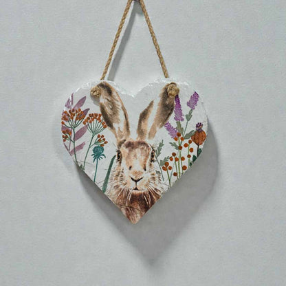 Heart-shaped wooden plaque with a hare illustration and floral elements on a light gray background.