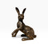 A bronze-finished sculpture of a sitting hare, shown on a clean white background.
