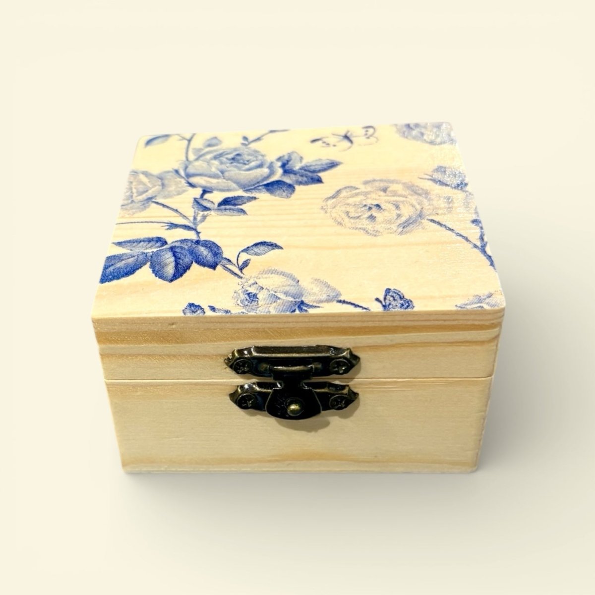 Wooden box with floral pattern on lid against a white background
