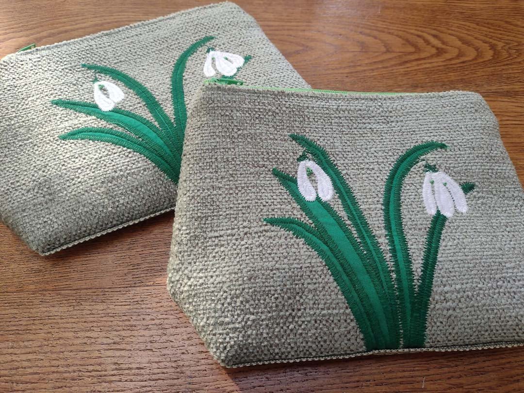 Two woven pouches with floral designs on a wooden surface_Just Makers