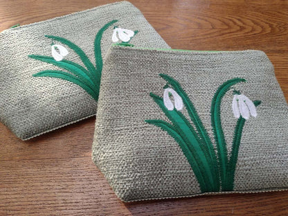 Two woven pouches with floral designs on a wooden surface_Just Makers