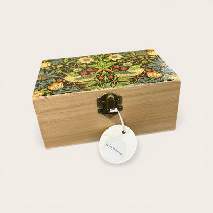 Wooden box with floral patterned lid and decorative tag on a white background
