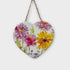 Heart-shaped wooden plaque with floral design hanging on a white background