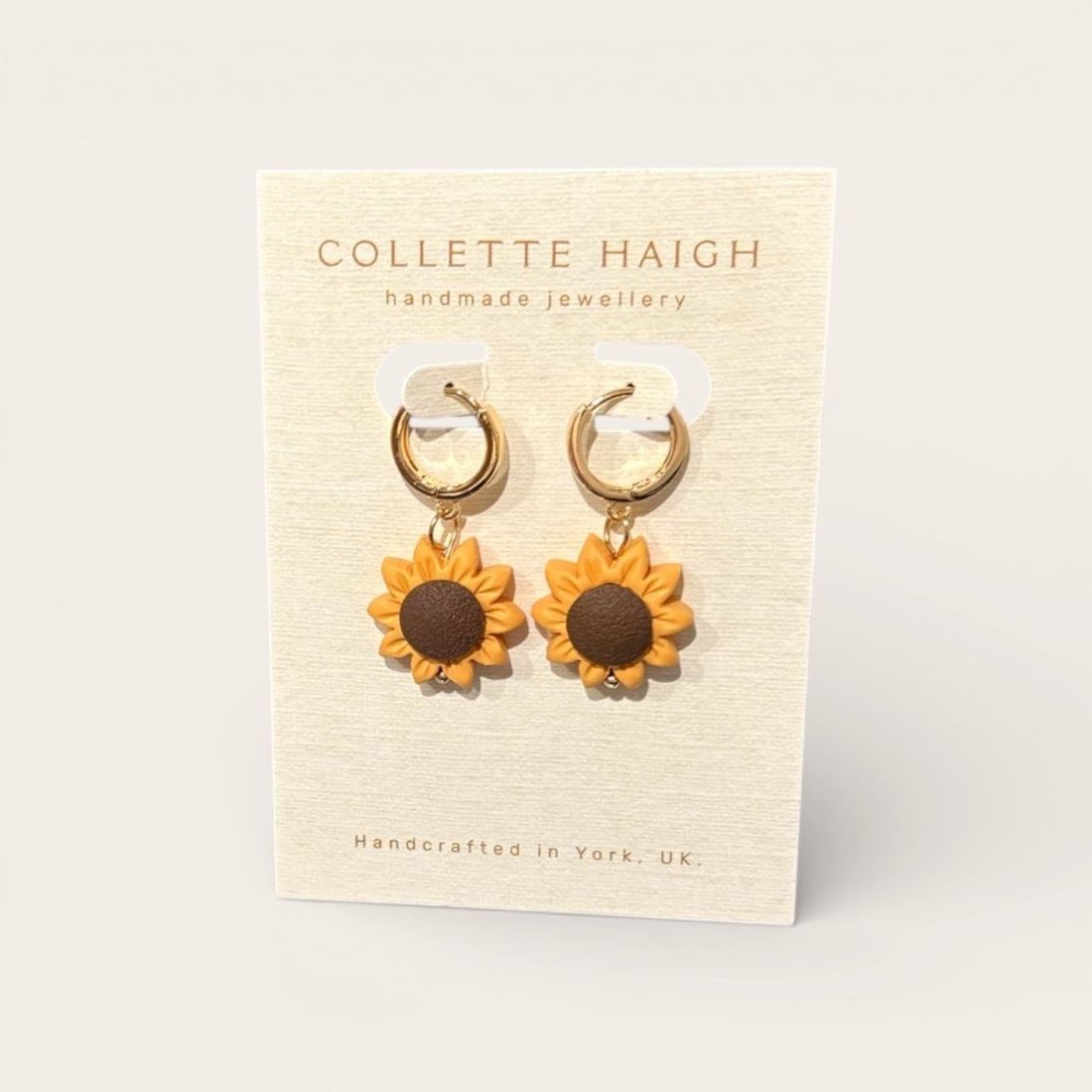 Sunflower earrings on a Collette Haigh branded card with a beige background