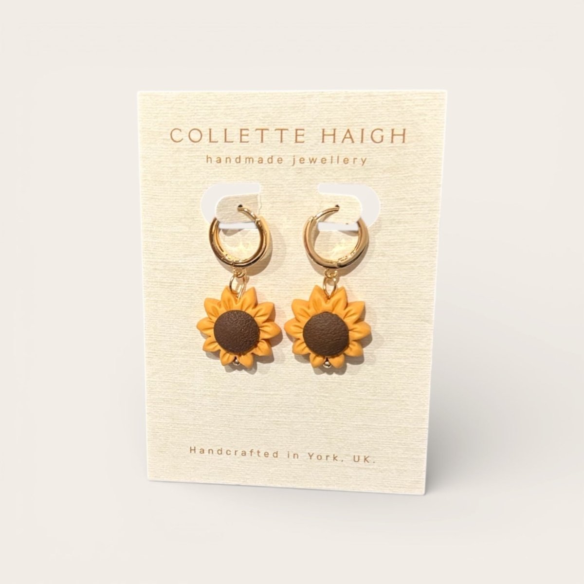 Sunflower earrings on a Collette Haigh branded card with a beige background