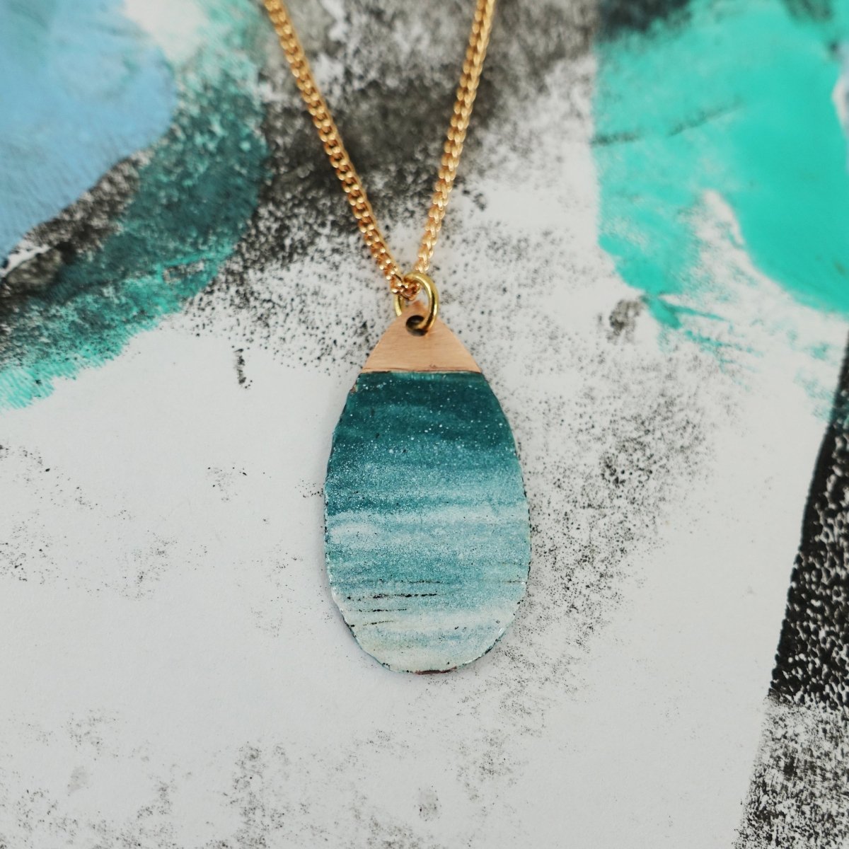 Necklace with a blue marbled pendant on a textured surface