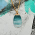 Necklace with a blue marbled pendant on a textured surface