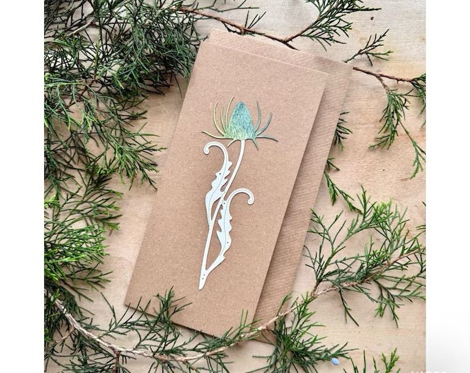 Kraft paper card with floral design on a bed of greenery
