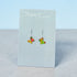 Butterfly-shaped earrings on a Nancy Jones card against a light blue background