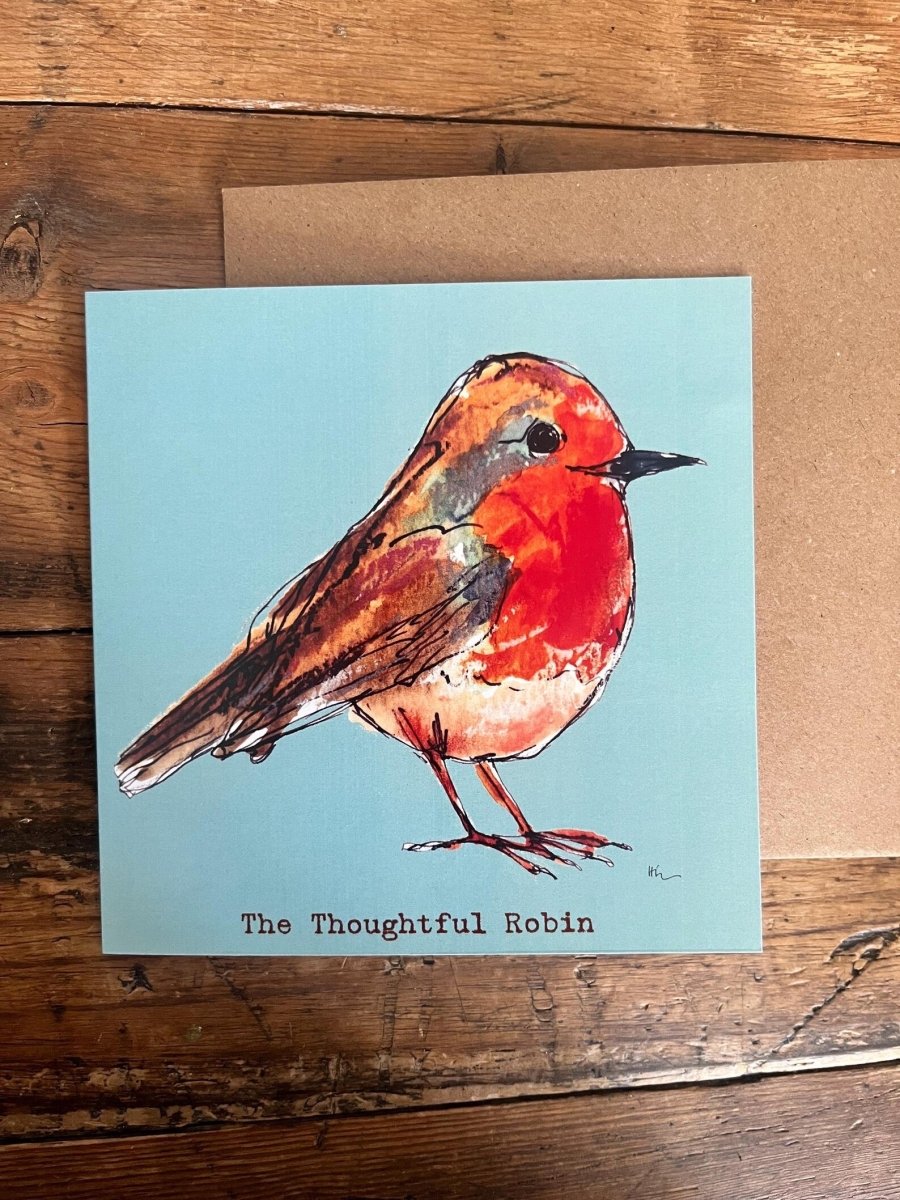 Card with a robin illustration on a wooden surface