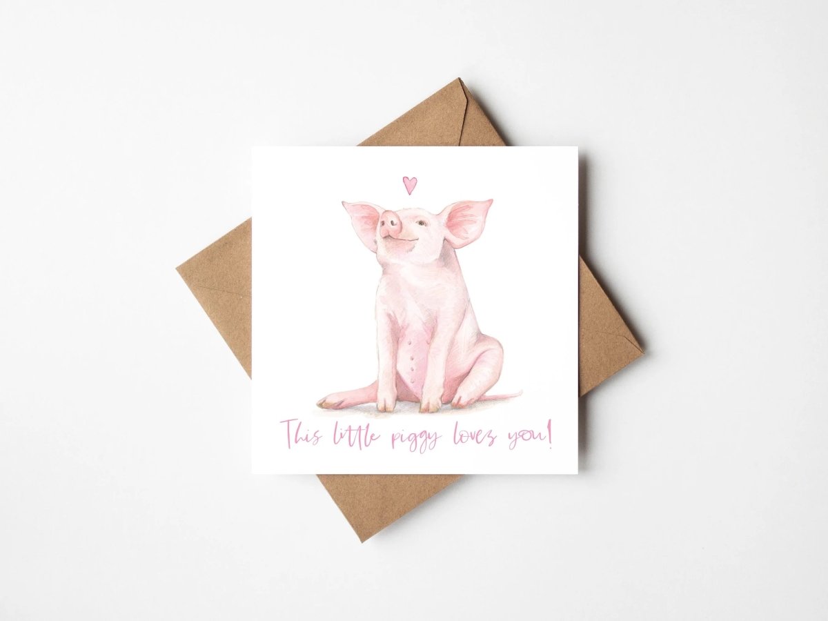 Greeting card with a pig illustration and text, accompanied by a brown envelope on a white background.