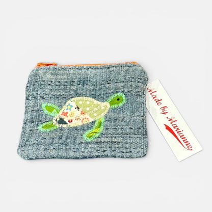 Textured pouch with a turtle design and a tag reading &