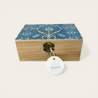 Wooden box with decorative blue lid featuring floral patterns on a white background
